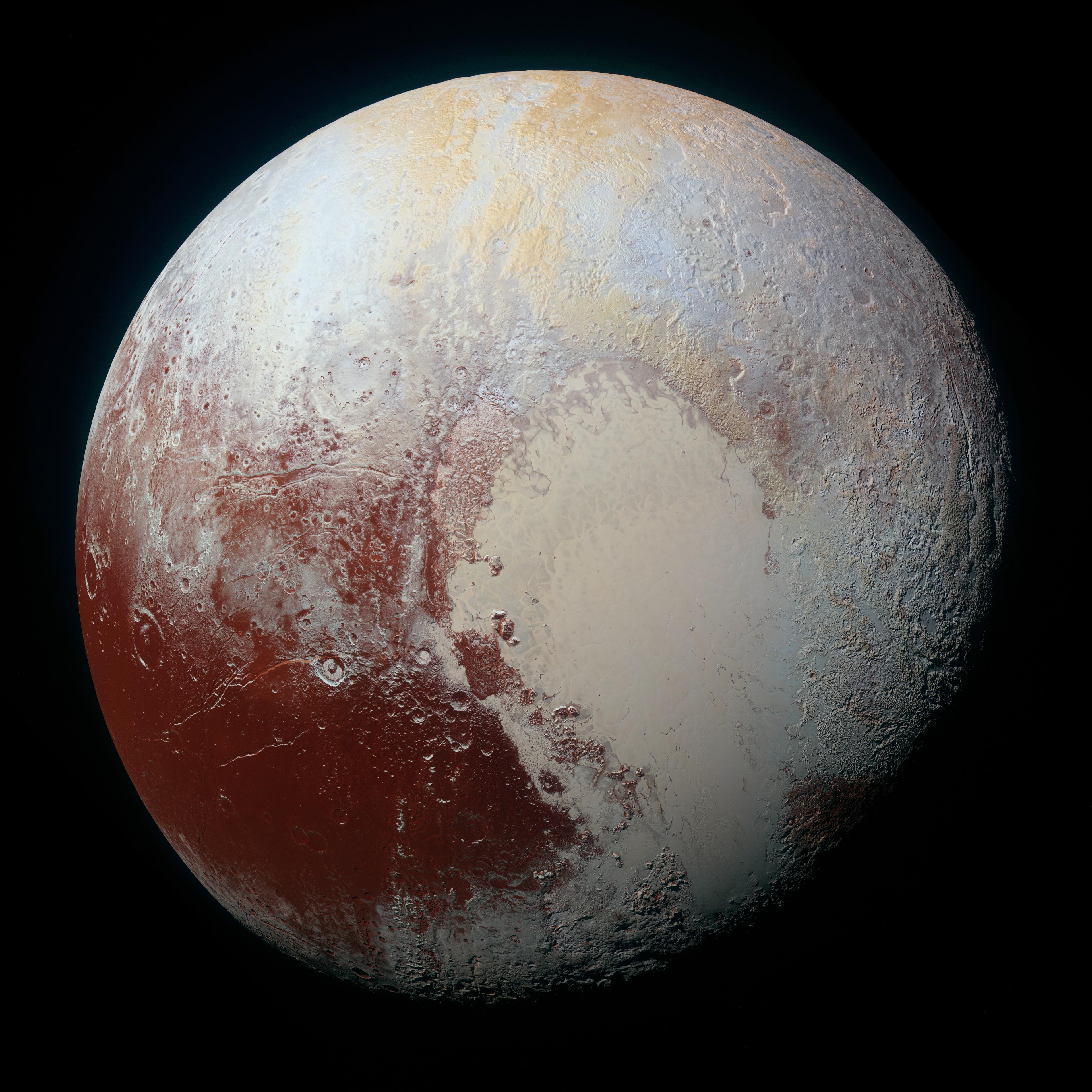 An image of the planet Pluto. It has large splotches of tan and red.